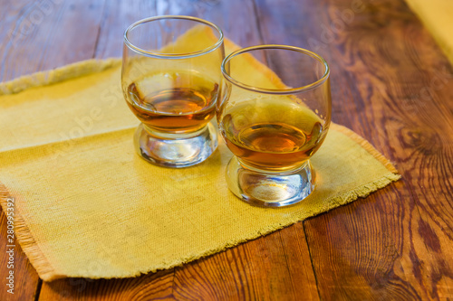 Two cognac bowls of brandy on the rustic table