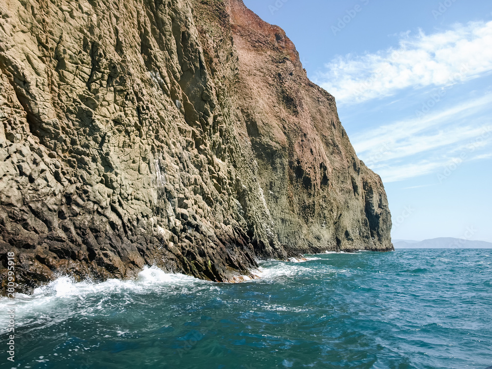 Textured steep rocks of volcanic origin on the sea coast