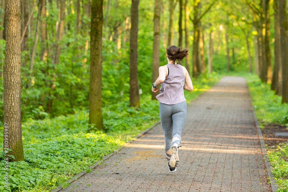 young woman runs in a forest and makes fitness young woman runs in a forest and makes fitness