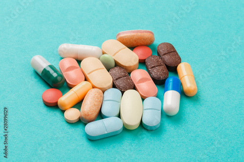 colour tablets and pills on blue background .