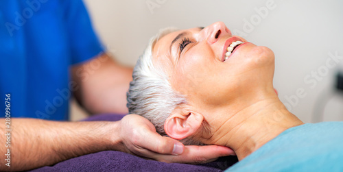Physical Therapist Working with Neck. Senior Woman