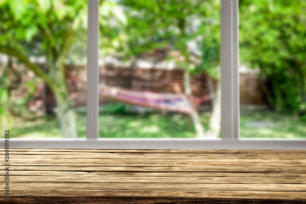 Naklejka premium Wooden desk of free space and window background 