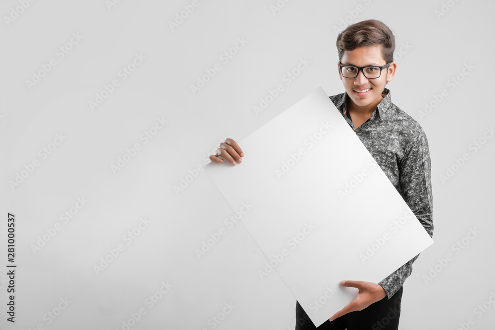 Indian/Asian Male college student showing blank signboard Indian/Asian Male college student showing blank signboard