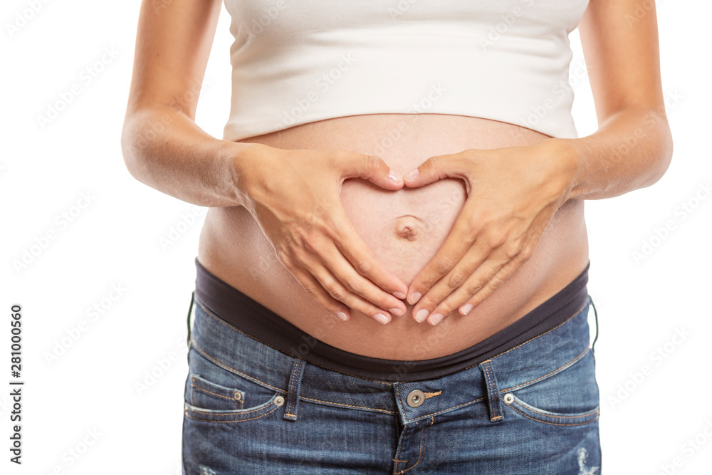 Pregnancy late term, close-up. Hands folded in the shape of a heart on a big belly. Isolated on a white background. Pregnancy late term, close-up. Hands folded in the shape of a heart on a big belly. Isolated on a white background.