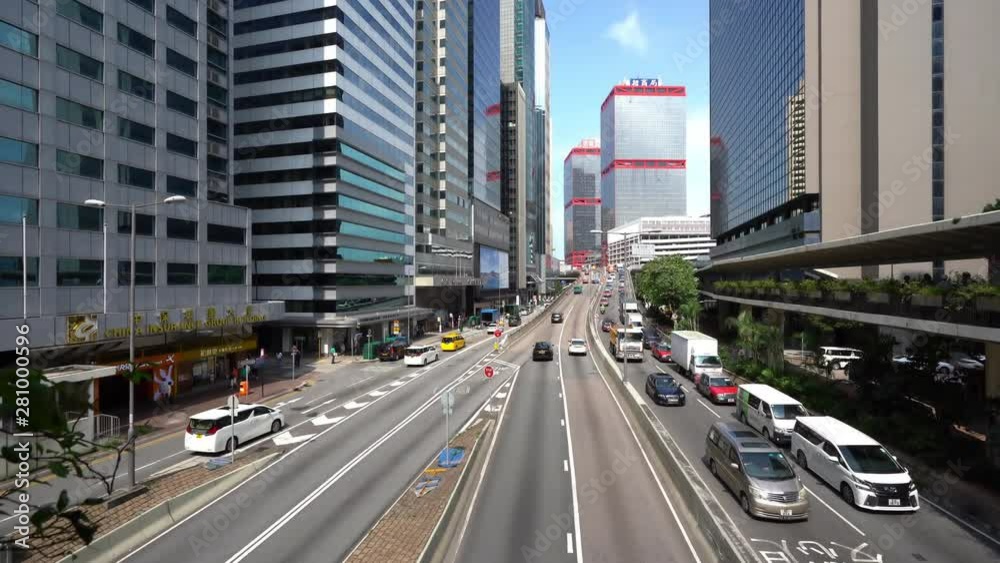 Hong Kong highway in daylight, pan across road between skyscrapers Hong Kong highway in daylight, pan across road between skyscrapers