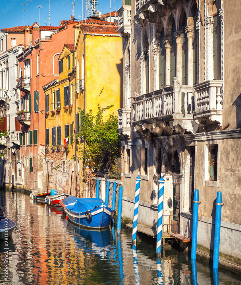 Traditional narrow canal in Venice, Italy. Medieval old buildings with a Renaissance balcony.