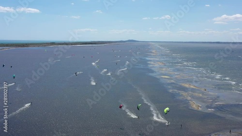 Men kitesurfing on Etang de Thau aerial shot windy sunny day France