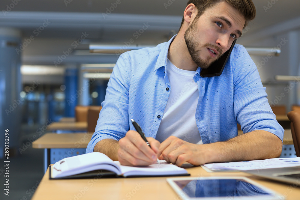 Businessman using his mobile phone in the office. Businessman using his mobile phone in the office.