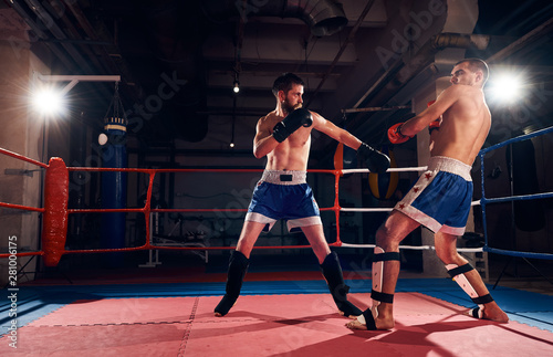 Muscular male fighter training kickboxing with sparring partner in the ring at the health club © anatoliy_gleb
