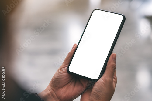 Mockup image of a hand holding black mobile phone with blank desktop screen