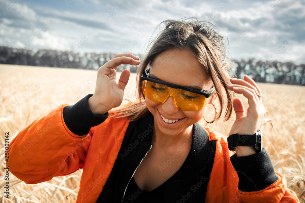 The girl in bright orange glasses and orange jacket.Bright girl.Girl in rye.Summer photos of a beautiful girl in the field. The girl in bright orange glasses and orange jacket.Bright girl.Girl in rye.Summer photos of a beautiful girl in the field.