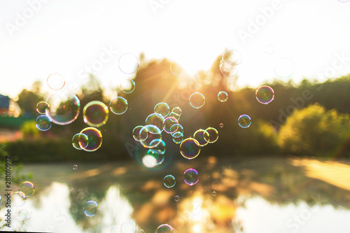 beautiful background with soap bubbles at sunset lake