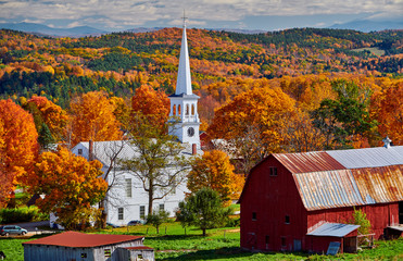 Congregational Church and farm with red barn at sunny autumn day in Peacham, Vermont, USA