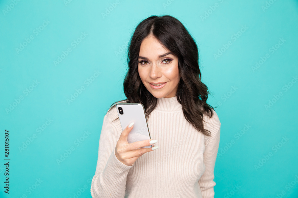 Attractive woman with mobile isolated on the blue background