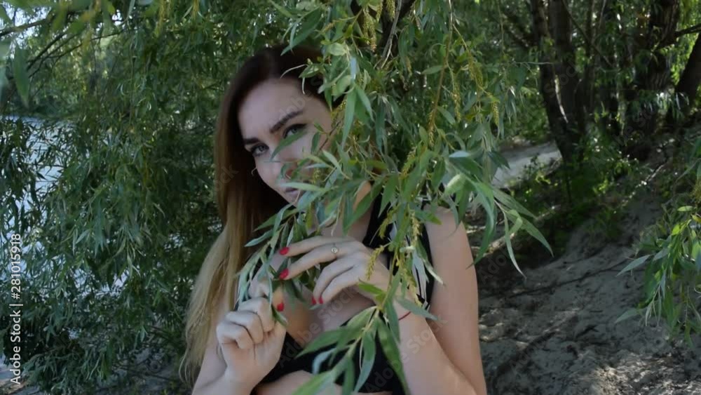 Portrait of a young brunette girl in a black swimsuit on a background of green foliage in the tropics in nature. Portrait of a young brunette girl in a black swimsuit on a background of green foliage in the tropics in nature.