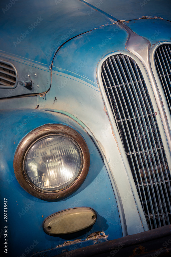 Headlight of a vintage blue classic car
