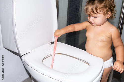 Child labor. Little girl cleans a toilet.