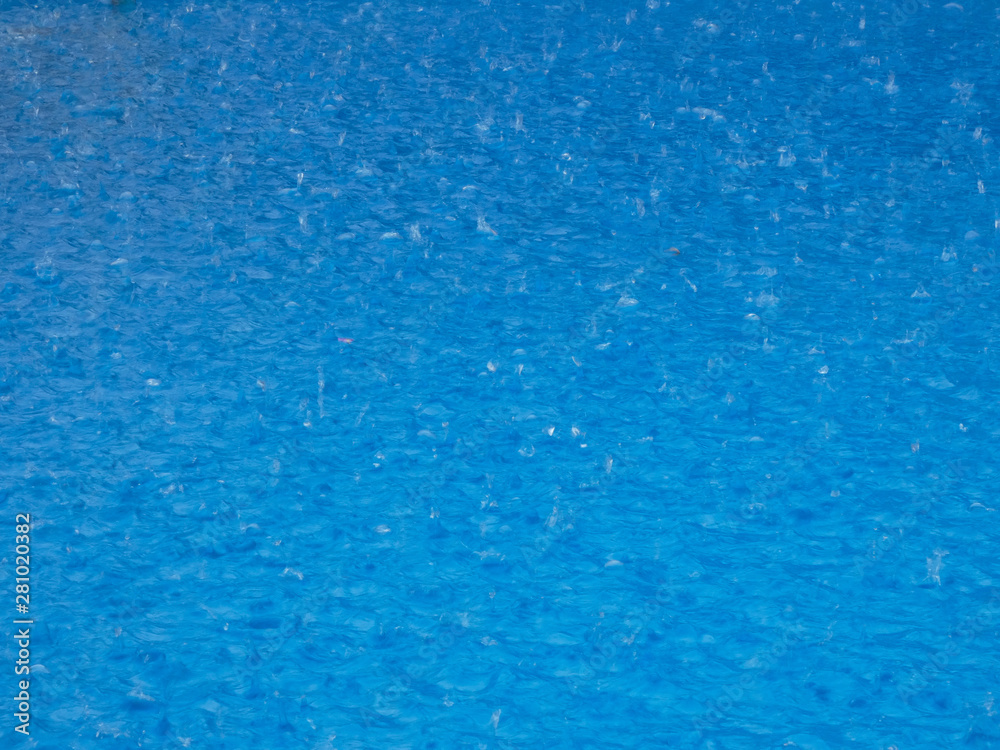 Lluvia cayando en el agua de una piscina; tormenta sobre una piscina