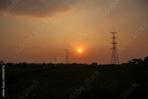 Twilight scenery with a backdrop of electric towers in beautiful rice fields