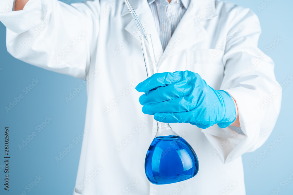 Young scientist with test tube making research in clinical laboratory.Professional science specialist at work. Young scientist with test tube making research in clinical laboratory.Professional science specialist at work.