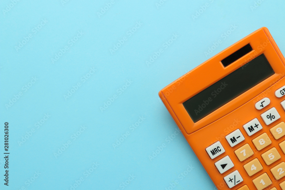 Orange calculator on a bright blue paper background. Office supplies. Education. back to school. top view. place for text. - obrazy, fototapety, plakaty 