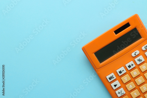 Orange calculator on a bright blue paper background. Office supplies. Education. back to school. top view. place for text. photo