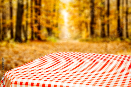 Table background with green autumn forest and orchard in distance. Empty  space for your decoration and an advertising product.