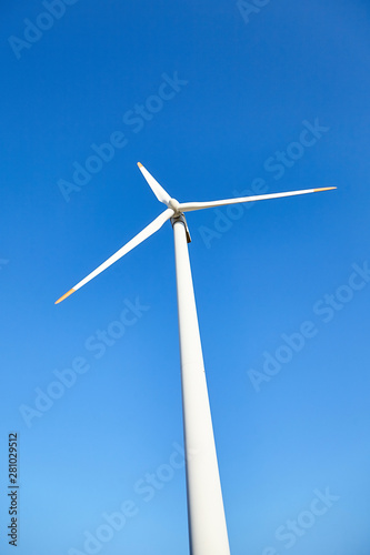 Wind power turbine against a blue sky background. Alternative energy. Renewable energy source © mikeosphoto