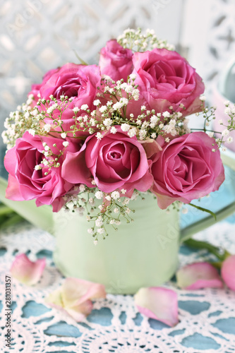 bunch of pink roses in a mint watering can