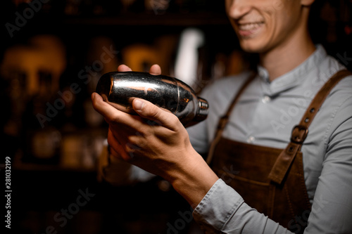 Close shot of shaker in bartender's hands
