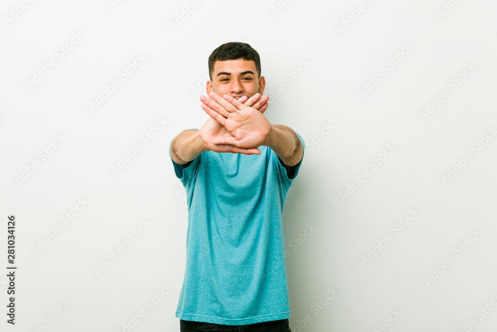 Naklejka premium Young hispanic man doing a denial gesture