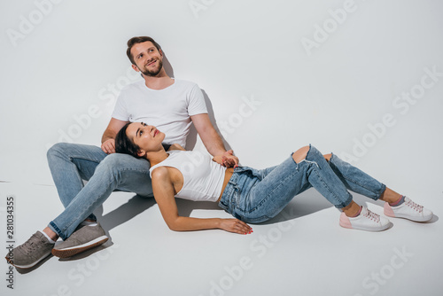 beautiful girl lying on knees of boyfriend while smiling and looking away
