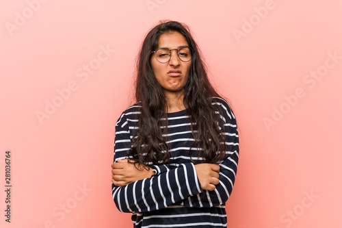 Young intellectual indian woman unhappy looking in camera with sarcastic expression.