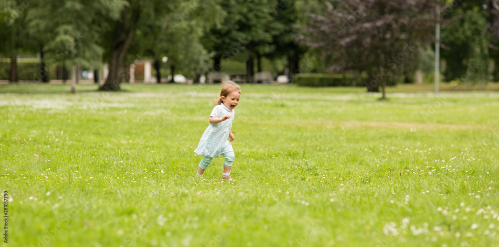 childhood, leisure and people concept - happy little baby girl running at park in summer