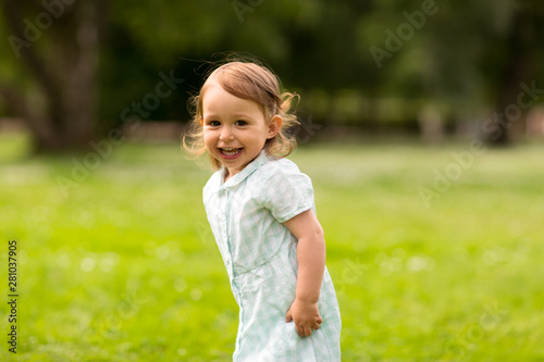 childhood, leisure and people concept - happy little baby girl at park in summer