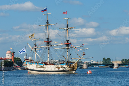 old military sailing ship "Poltava" parked on the Neva River in St. Petersburg against the blue sky and city