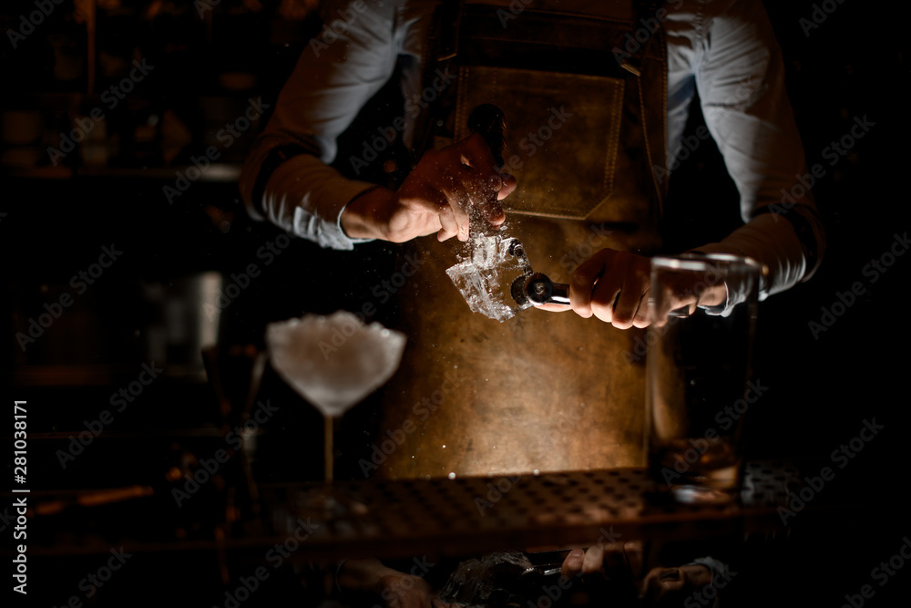 Bartender crushing the ice cube with picker Bartender crushing the ice cube with picker