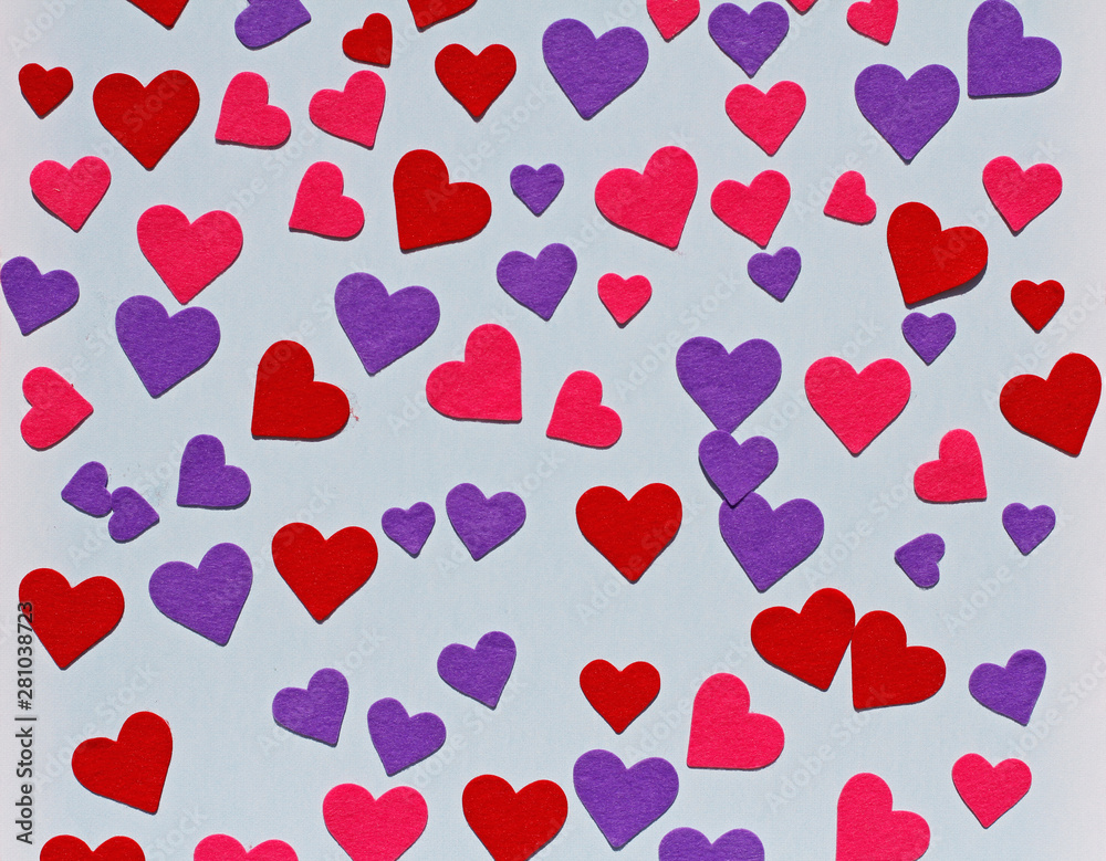 Red, pink and purple felt hearts on blue background