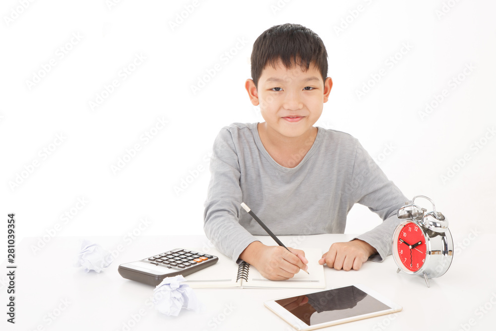 Little asian boy use pencil writing on notebook with smiling face on white background. Planing Education Concept. Little asian boy use pencil writing on notebook with smiling face on white background. Planing Education Concept.