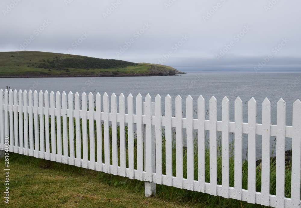 white wooden picket fence along the oceans shoreline, Burin Peninsula Newfoundland Canada