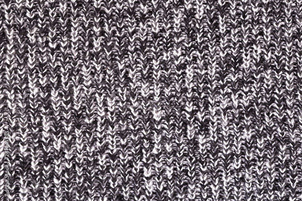 Fototapeta premium Background from a fabric texture. Wool knitted fabric with cable seamless pattern of white black color. Textile closeup.Concept of example, learning of knitting,concept of cover,notebooks, decorative 