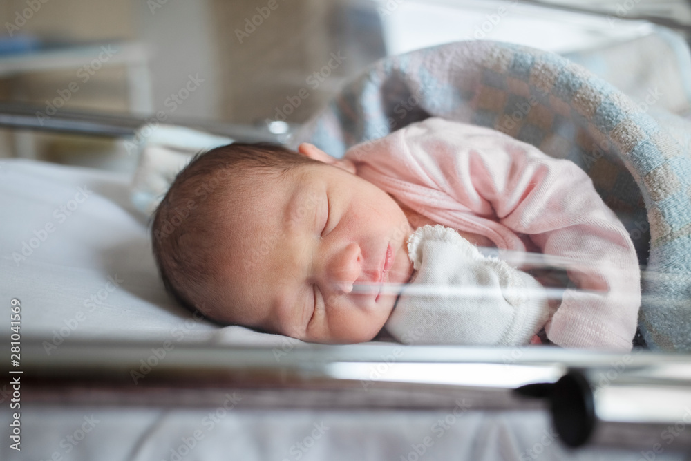 A newborn baby sleeps in the maternity hospital. Little baby resting after birth - obrazy, fototapety, plakaty 