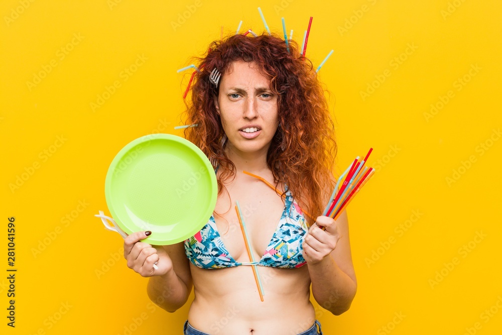 Young caucasian redhead woman angry with the abusive use of plastic Young caucasian redhead woman angry with the abusive use of plastic
