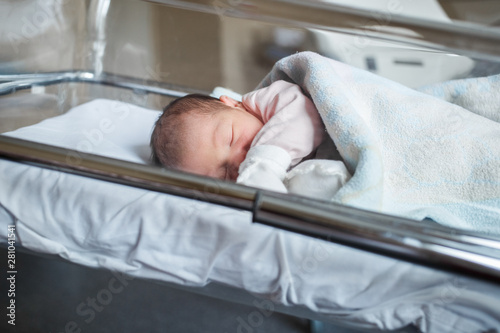 A newborn baby sleeps in the maternity hospital. Little baby resting after birth
