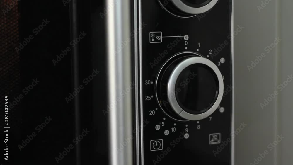 Setting microwave timer to ten minutes and turning microwave off - close angled shot Setting microwave timer to ten minutes and turning microwave off - close angled shot