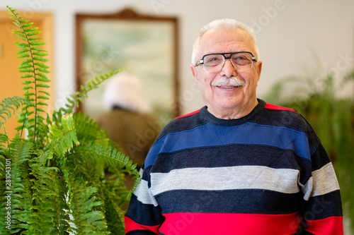 Portrait of smiling and confident senior man 70-75 years old with eyeglasses. Text space for ad