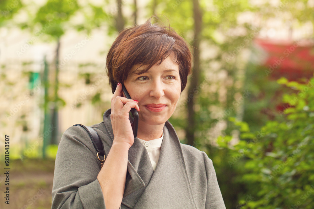 Pretty mature woman phone, outdoors portrait Pretty mature woman phone, outdoors portrait