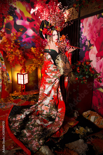 Foto Geisha morena con paraguas y abanico
