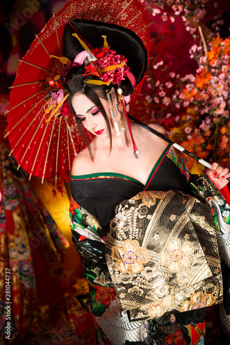Foto Geisha morena con paraguas y abanico