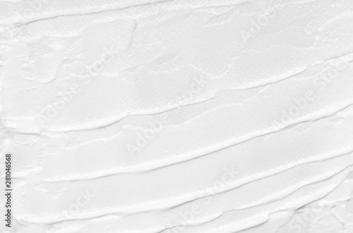 Texture of white face cream smeared on a white background. Cosmetic texture, face and body care.